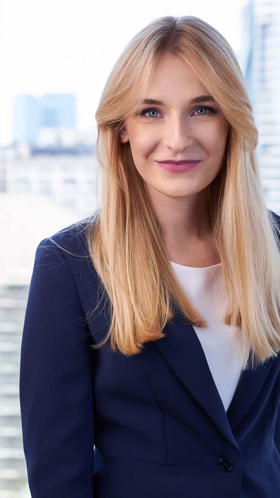 Executiva loira em blazer navy — ambiente corporativo